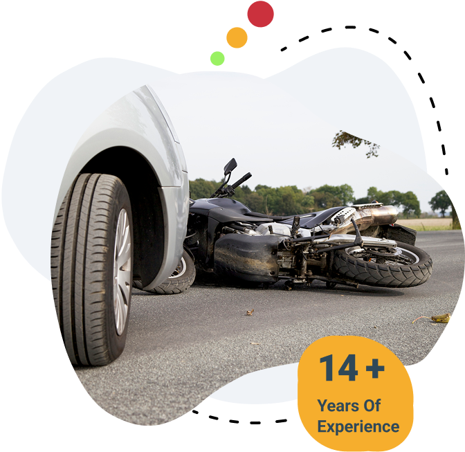 Damaged motorcycle lying on the road after a collision with a white car